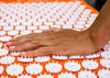 Eine Hand befühlt die einzigartige Clip-Disk-Technologie der Shakti Mat.